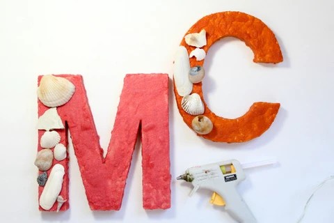 Hot glue seashells to a wood letter painted with colored sand.